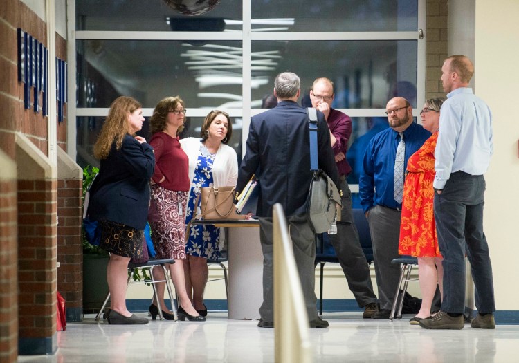 Peter Felmly, center, back facing, an attorney with Drummond Woodsum, speaks with SAD 49 principals and vice principals along with SAD 49 school board Chairman, Shawn Knox, far right, Thursday during a sidebar session following an executive session  at an SAD 49 school board meeting at Lawrence Junior High School in Fairfield.