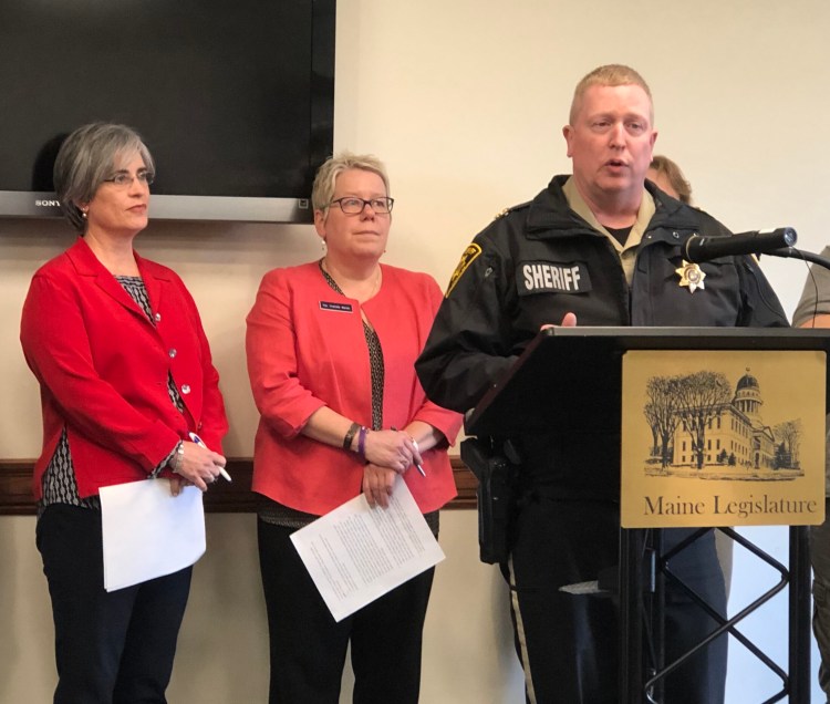 Penobscot County Sheriff Troy Morton speaks Wednesday in favor of a bill that would form a working group to review problems and recommend solutions for Maine’s ailing mental health care system. Behind Morton are the bill’s sponsors, Sen. Cathy Breen, D-Falmouth, left, and Rep. Charlotte Warren, D-Hallowell.