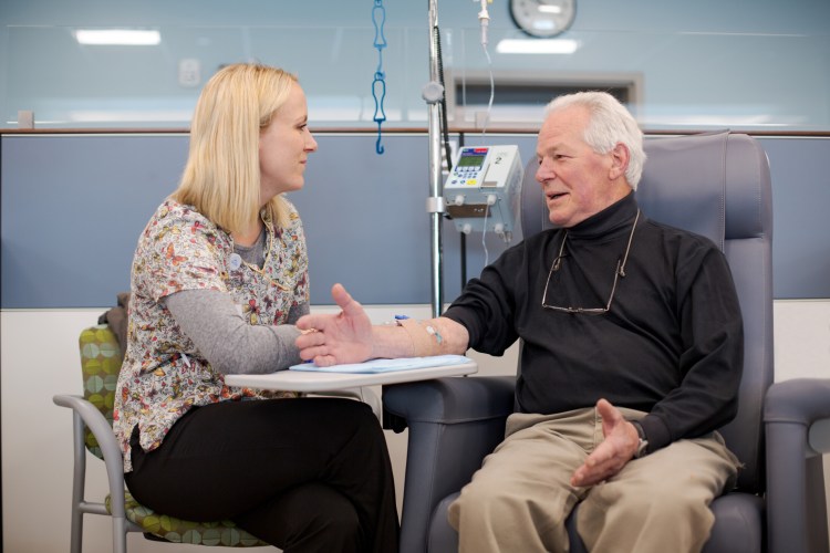 Eileen Stirling, RN, BSN of New England Cancer Specialists’ Topsham office, with Roy Jenkins of Wiscasset, a lung cancer survivor.