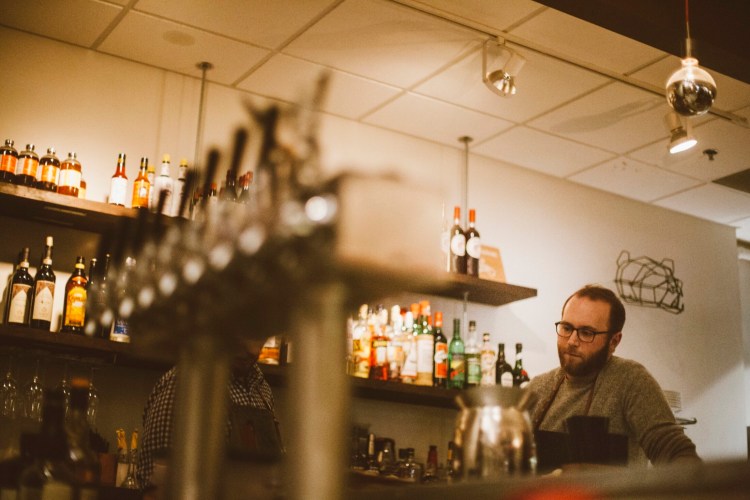 Andrew Volk, shown here tending bar at Portland Hunt + Alpine Club, hopes to get city approval for outdoor seating in a parking space.