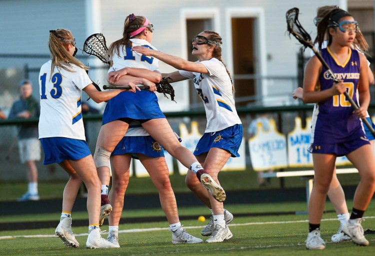 Falmouth's Caitlyn Camelio, 12, is swarmed by teammates after scoring the tie-breaking goal and eventual winner late in the second half Friday against Cheverus.