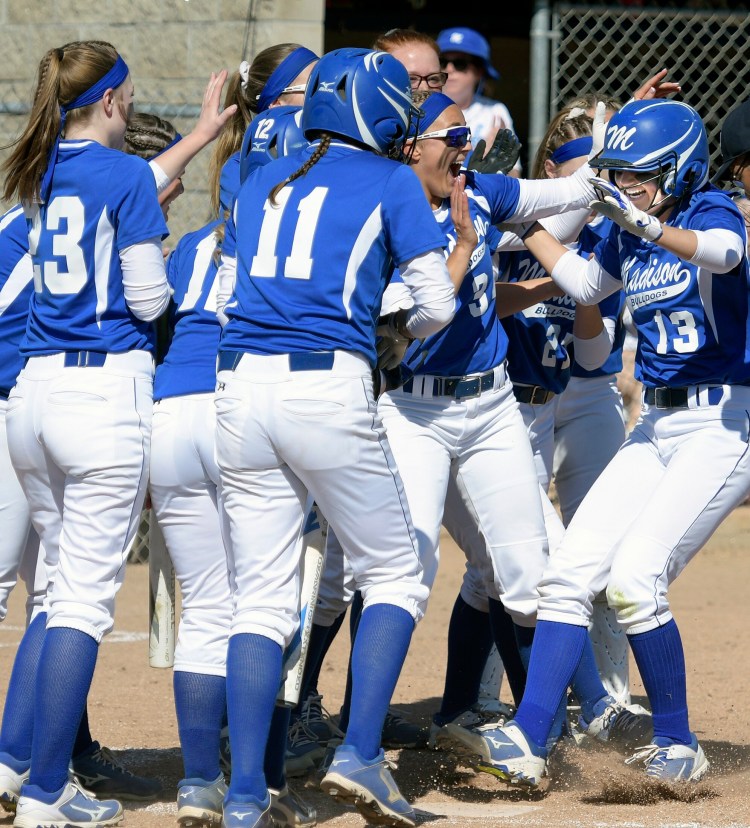 Madison softball players mob Emily Edgerly at home plate after she hit a two-run homer during the Class C South title game against Sacopee on Wednesday at St. Joseph's College in Standish.