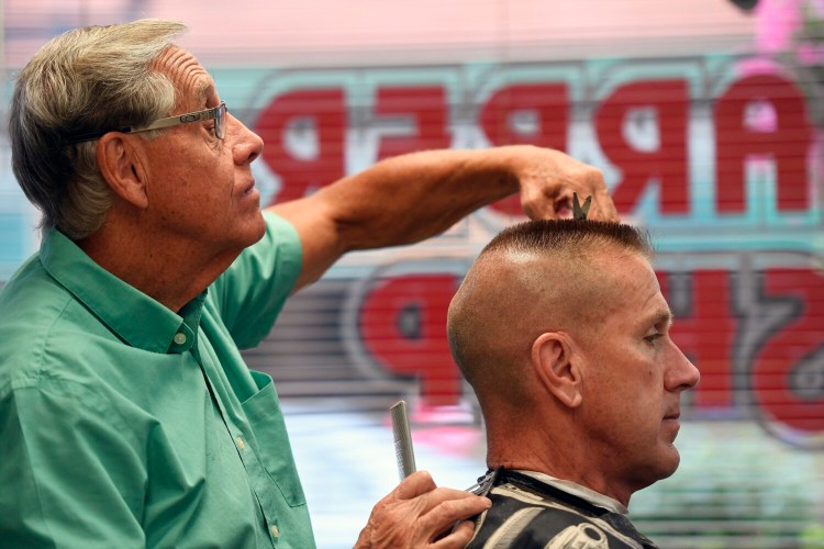 Roger Chretien of Roger's Barber Shop in Biddeford gives a high and tight flattop haircut to Ken Mason of Arundel Thursday.