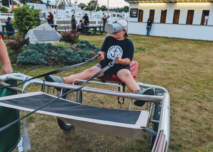 A young fan tries the Maine Harness Horseman's Association's new virtual reality simulator at the Skowhegan State Fair in Skowhegan this week.