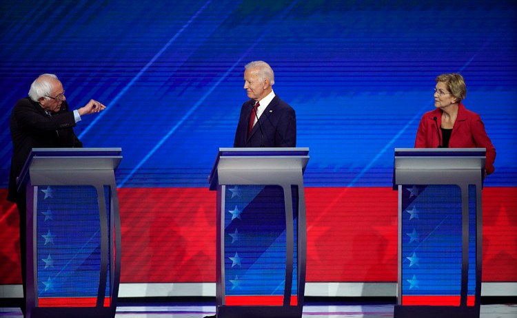 Former Vice President Joe Biden and Sen. Elizabeth Warren listen as Sen. Bernie Sanders speaks Thursday during the Democratic presidential debate in Houston.