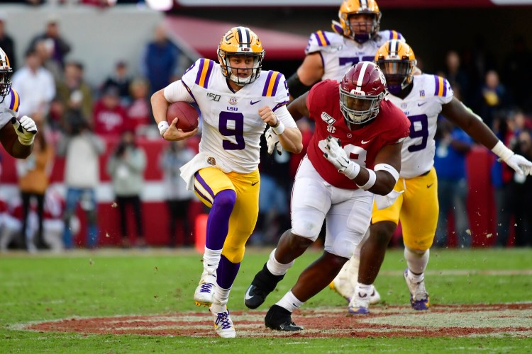 LSU quarterback Joe Burrow runs as Alabama defensive lineman Phidarian Mathis chases him in the first half  Saturday in Tuscaloosa , Ala. 