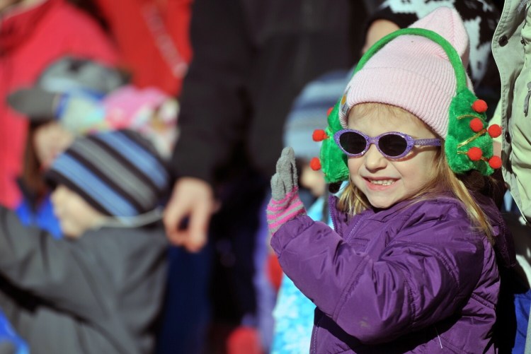 Gracie McCourt, 3, waves as floats roll down Main Street during a past Chester Greenwood Day parade in Farmington.