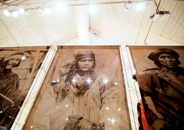 Banners display photographs of Native American people dressed in regalia, and clothing worn for special occasions such as ceremonies, celebrations, and political gatherings at an exhibit in Bar Harbor.