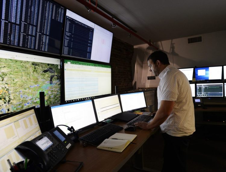 Jake Theriault remotely observes solar and wind projects across the country from Longroad Energy Partners' $1 million facility in downtown Portland. The company sold its ownership stake in a Hancock County wind farm to a Canadian investment firm, but will build and operate the 22-turbine Weaver Wind.