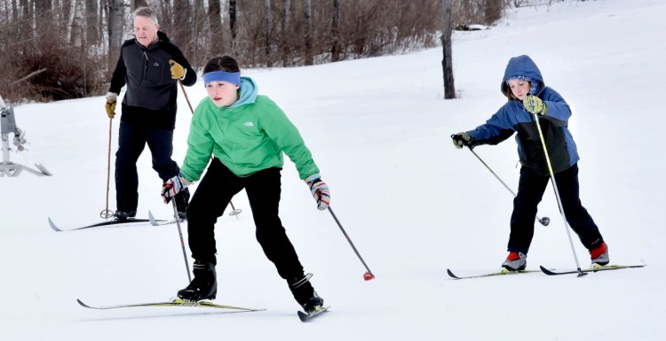 Maeve Lakin, center, and her brother John race on cross-country skies on trails at the popular Quarry Road Recreation Area in Waterville last year.