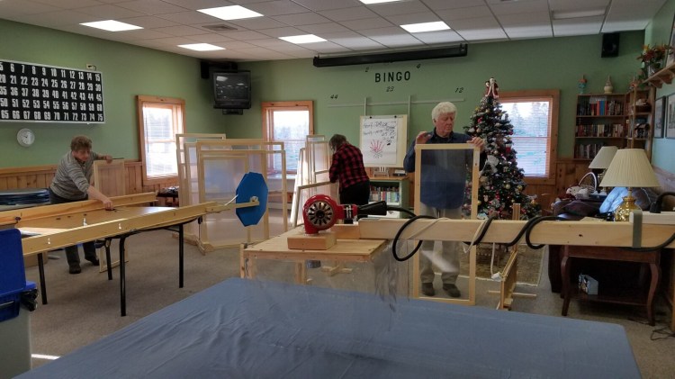 From left, Ramona Varney, Ellen Casey and Prentice Gourde put finishing pieces on inserts.