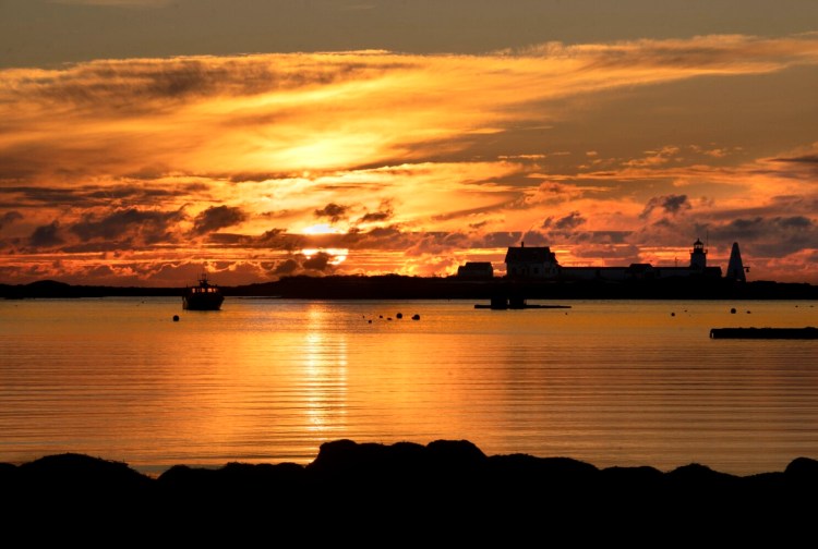 CAPE PORPOISE, ME - JANUARY 1: The sun rises behind Goat Island lighthouse in Cape Porpoise at dawn on New Year's Day, January 1, 2020. (Staff Photo by Gregory Rec/Staff Photographer)