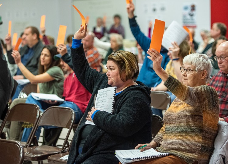 Sue Callahan, left, and her mother-in-law, Judy Callahan vote for an article in the Minot Town Meeting on March 7.