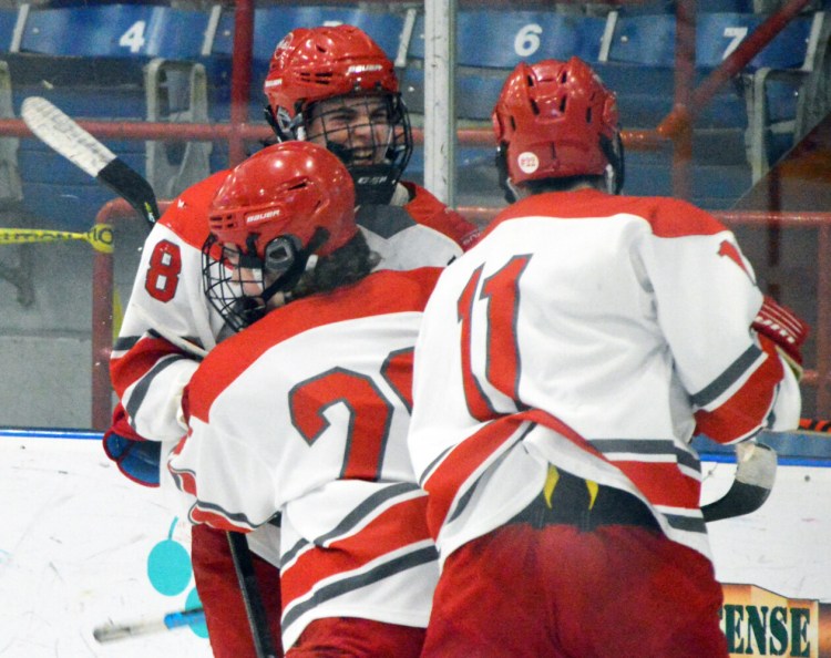 Eric Walker of South Portland/Freeport/Waynflete celebrates with teammates after scoring his team's third goal late in the second period. The Red Riots rallied to a 5-4 Class A quarterfinal victory over Thornton Academy at the Androscoggin Bank Colisee in Lewiston on Friday.