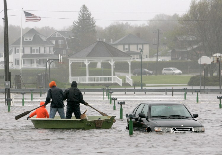 Cameron Kimball, 15, Mike Chapman, 15, and David Young, 25, float through a parking lot at York Beach on May 14, 2006.
