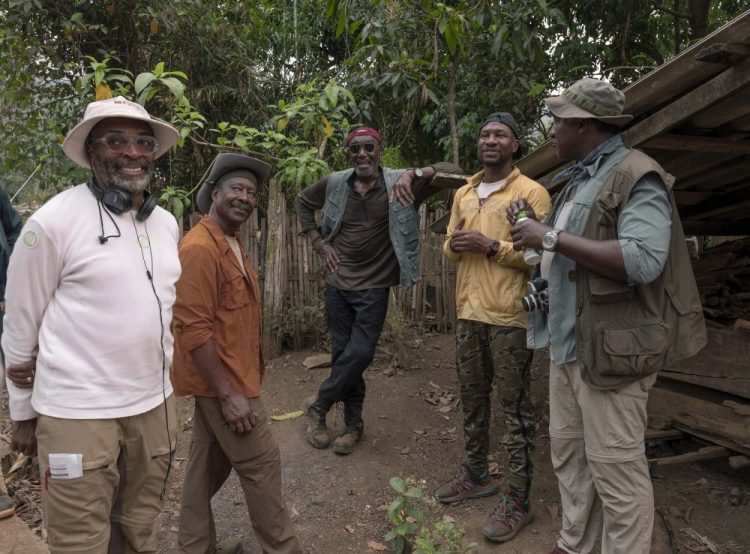 This image released by Netflix shows, from left, filmmaker Spike Lee, from left, with Clarke Peters, Delroy Lindo, Jonathan Majors and Norm Lewis on the set of "Da 5 Bloods." 