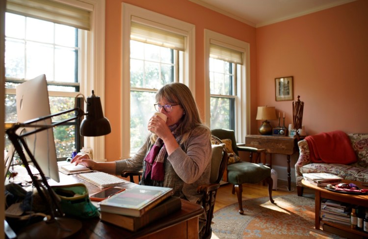 Clara Parkes, an author who lives in Brooksville, works on her computer in her Portland apartment last week. Parkes keeps the apartment in Portland for when she needs to do work that demands a strong broadband connection, something she lacks in Brooksville.