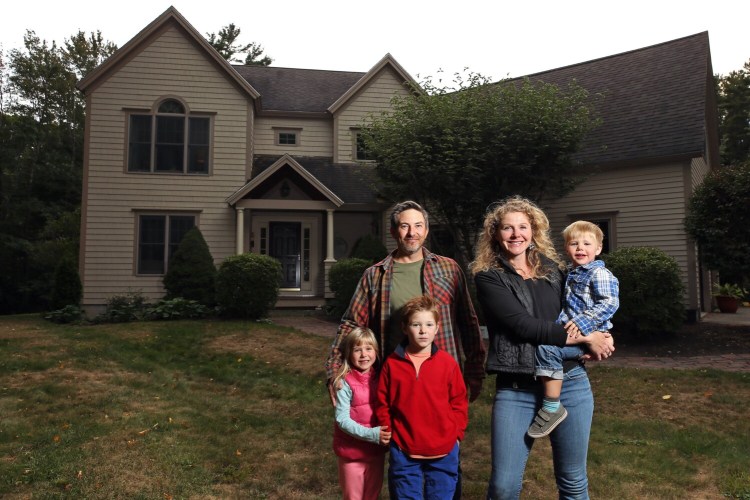 Matt and Elli Carter and their children, Maeve, left, Alden and Reed in front of the home in Cape Elizabeth they bought this summer. Low interest rates and rising prices allowed the Carters to refinance their home just four months after they bought it.