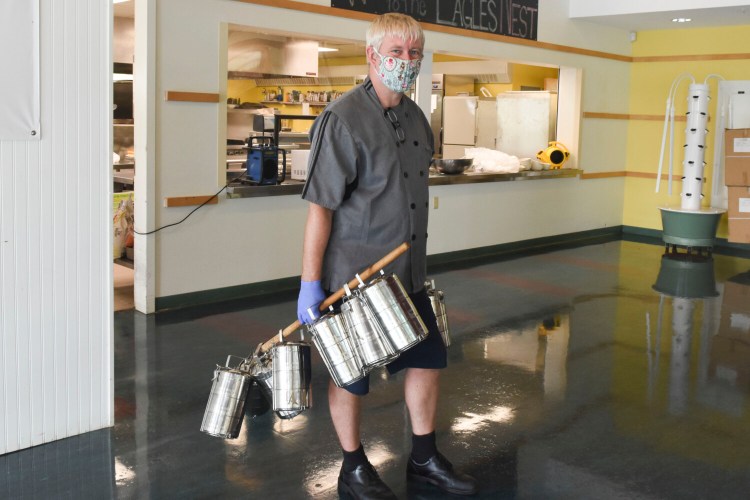 Chef Mikael Andersson collecting LA’s new tiffin boxes after lunch. He uses an old broomstick to collect the tiffins from classrooms, a technique he refers to with a laugh as “old world technology."