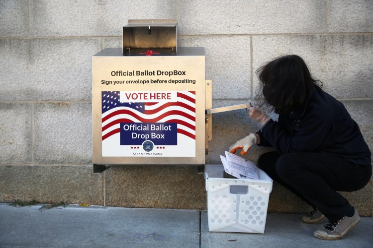 PORTLAND, ME - NOVEMBER 3: Chris Horne, a staffer with the Portland City Clerk's Office, unloads absentee ballots from a drop box at City Hall on Tuesday morning. Horne said she had unloaded the box three times by 10:30 a.m. and usage has been heavy, particularly overnight. (Staff photo by Ben McCanna/Staff Photographer)