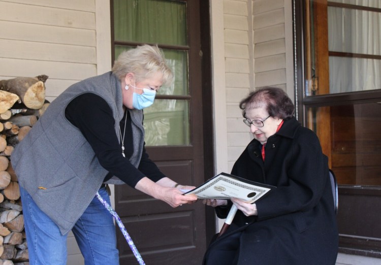 Valerie Dawes, left, of Manchester Historical Society, makes a presentation Nov. 21 to Manchester's oldest citizen Muriel Tabbutt.