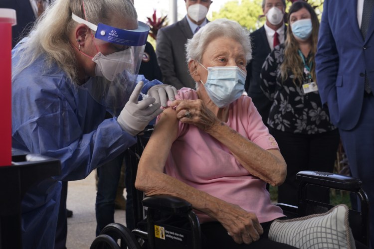 Nurse Christine Philips administers the Pfizer vaccine to Vera Leip, 88, a resident of John Knox Village, on Wednesday in Pompano Beach, Fla. Nursing home residents and health care workers in Florida began receiving the Pfizer vaccine this week. 