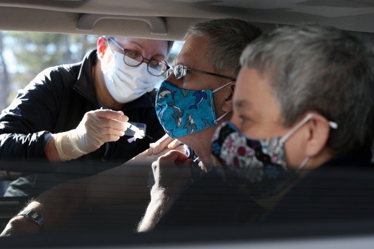 Greg Barlag, center, a client at Community Living, receives a first dose of a coronavirus vaccine Monday in Brunswick. About 200 peeopl with intellectual disabilities and their service providers received the vaccine at a drive-thru vaccination clinic.