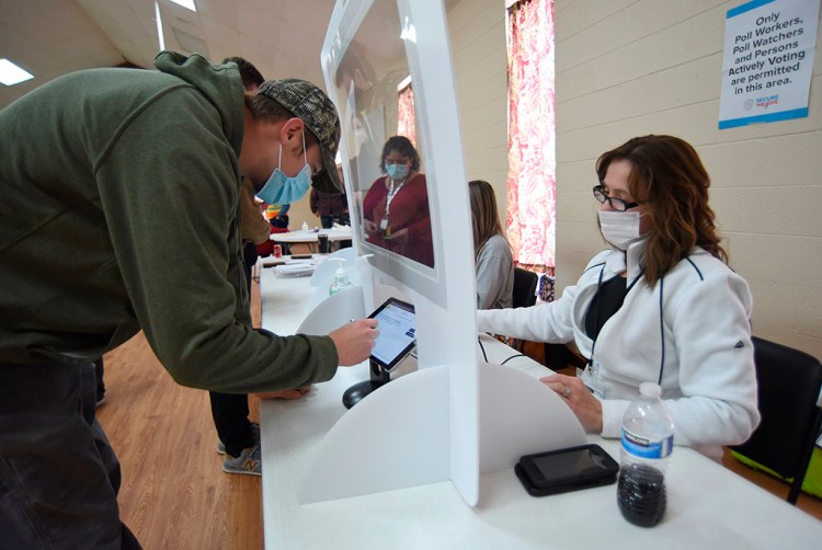 Poll worker Jennifer Jones signs in Taylor Ledford at the polling place at Dawnville United Methodist Church in Dawnville, Ga., on Tuesday.