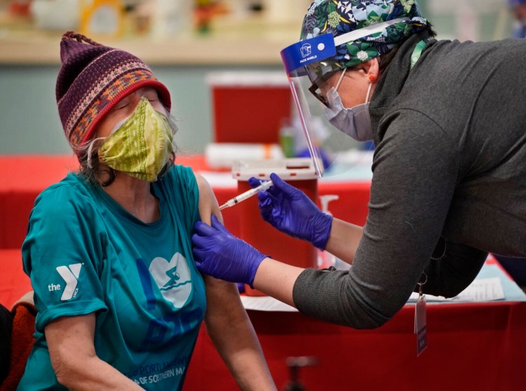 Mary Robbins administers a COVID-19 vaccine to Caron Chess during an immunization clinic on Peaks Island on Sunday.