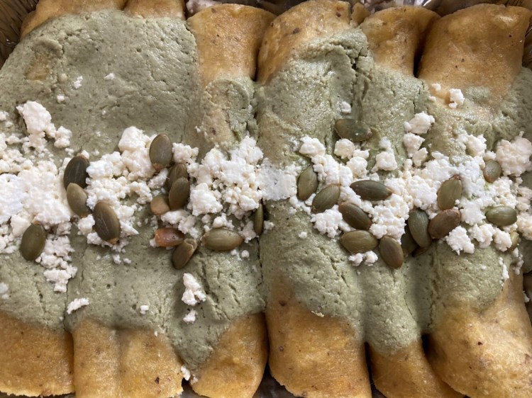 Straight from the box and ready to reheat: black bean, potato, mushroom enchiladas with green pumpkin seed sauce. 