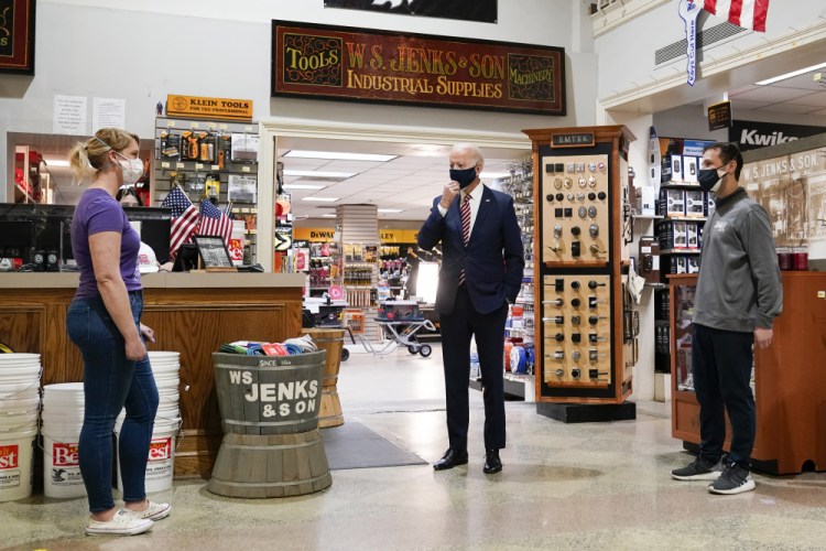 President Biden speaks with Mary Anna Ackley, owner of Little Wild Things Farm, left, and Michael Siegel, Co-owner of W.S. Jenks & Son, right, during a visit at W.S. Jenks & Son hardware store, a small business that received a Paycheck Protection Program loan, on Tuesday in Washington. 