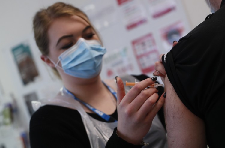 Pharmacy Technician Katrina Bonwick administers a dose of the AstraZeneca COVID-19 vaccine at the Wheatfield surgery in Luton, England, on Thursday. 