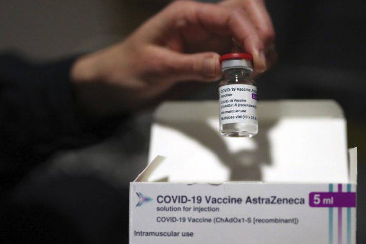 A medical staff dispays AstraZeneca COVID-19 vaccine at a vaccination site set up in the Marseille soccer Velodrome stadium, during a presentation to the media, in Marseille on Monday. France will suspend use the AstraZeneca vaccine until at least Tuesday afternoon while it reviews reports of blood clots in some people who had received the vaccine.