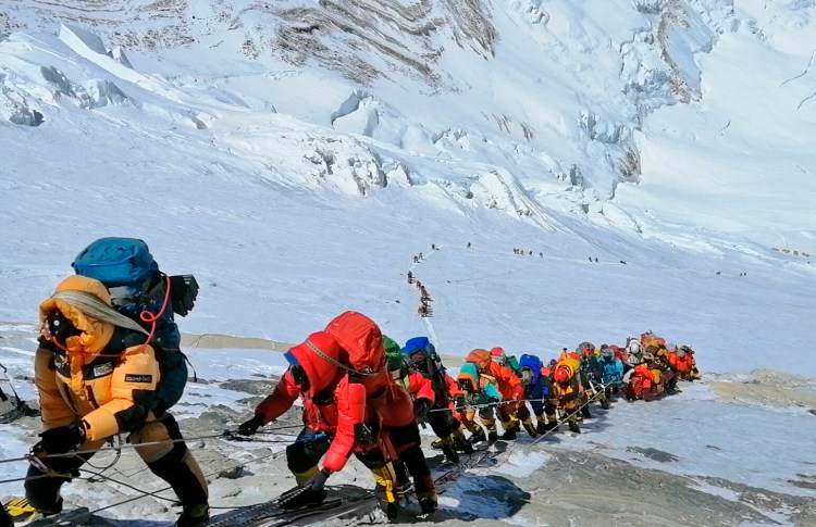 FILE - In this May 22, 2019, file photo, a long queue of mountain climbers line a path on Mount Everest just below camp four, in Nepal. Expedition operators on Mount Everest say that Chinese mountaineering officials will not allow spring climbs from their side of the mountain due to fears of the coronavirus. (AP Photo/Rizza Alee, File)