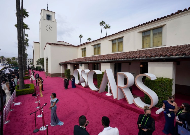 Maria Bakalova, from left, Andra Day and Regina King are interviewed and Marlee Matlin walks the red carpet at the Oscars on Sunday, April 25, 2021, at Union Station in Los Angeles. (AP Photo/Mark Terrill, Pool)