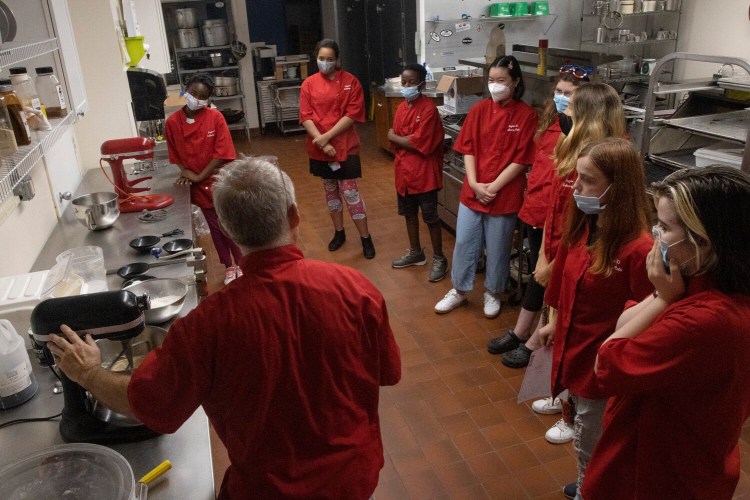 Students watch culinary arts instructor Tim Dean last week as he demonstrates the process of making chocolate chip cookies during a technical education summer camp at Region 10 Technical High School in Brunswick.