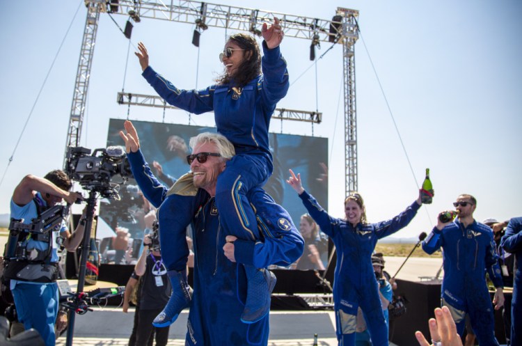 Virgin Galactic founder Richard Branson carries crew member Sirisha Bandla on his shoulders while celebrating their flight to space at Spaceport America near Truth or Consequences, N.M., on Sunday.