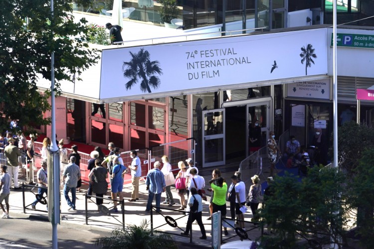 Members of the public walk in front of the Palais des Festival on Monday prior to the 74th international film festival, Cannes, southern France. The Cannes film festival runs from July 6 - July 17.