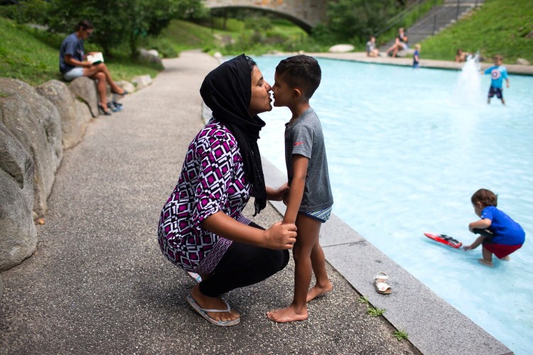 Sameera Khilwati kisses her son, Rustam Jamalzada, 5, as he takes a break from playing at Deering Oaks on Wednesday. With Rustam going into kindergarten at Rowe Elementary School in Portland, she is worried about COVID-19 and thinks it would be good if schools reopened online.