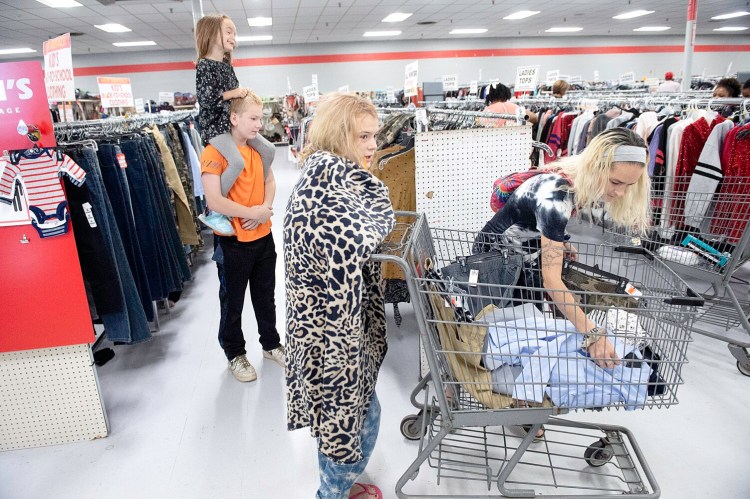 Teresa Pelletier, right, of Lewiston shops Saturday for back-to-school clothes for her children Raven, 5, Christian, 12, and Baronica, 14, at Marden's in Lewiston. The mother of five received a Marden's gift card for $70 from the Trinity Jubilee Center to help with the cost.