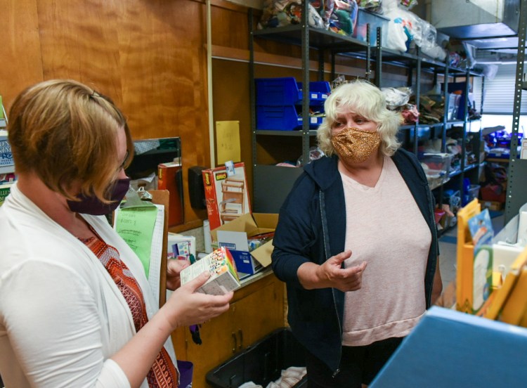 Melissa Lane, left, and Barbara Stevens, Promise Early Education Center teachers, browse the aisles Tuesday at the SHAREcenter in the former Martel Elementary School on Lisbon Street in Lewiston for art supplies. They use the center for materials for most of their activities and plan several units in advance. The center is looking for a permanent home.