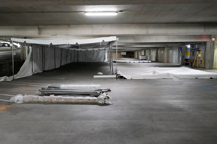 A tent awaits is partially assembled in a University of Mississippi Medical Center garage, Wednesday, Aug. 11, 2021, as the conversion of the parking facility into a field hospital begins in Jackson, Miss. The current wave of the Delta variant of COVID-19 is overburdening the hospital, causing them to make the conversion, capable of handling 50 beds. In addition, the Level 1 trauma care facility is receiving temporary federal medical personnel to augment the Medical Center's staff. 