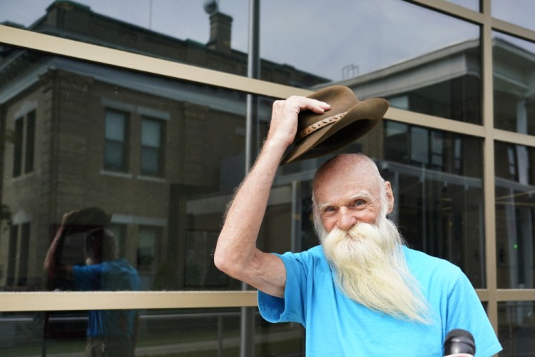 David Lidstone, an off-the-grid New Hampshire hermit known to locals as "River Dave," doffs his hat after speaking to media outside Merrimack County Superior Court after a status conference hearing, Wednesday, Aug. 11, 2021, in Concord, N.H. The court determined that Lidstone will be able to collect his cats, chickens, and remaining possessions from the site he has lived on for 27 years. 