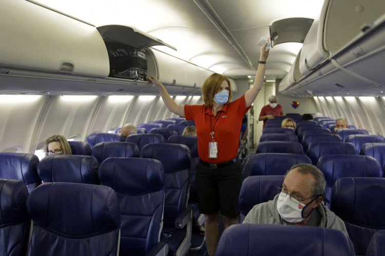 A Southwest Airlines flight attendant prepares a plane bound for Orlando, Fla. for takeoff Sunday, at Kansas City International airport in Kansas City, Mo. on May 24, 2020. 