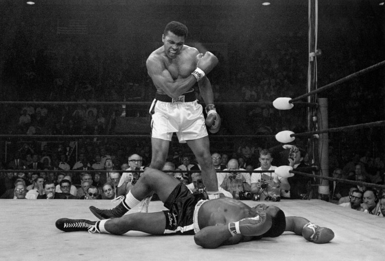 Heavyweight champion Muhammad Ali stands over fallen challenger Sonny Liston, shouting and gesturing shortly after dropping Liston with a short hard right to the jaw on May 25, 1965, in Lewiston, Maine.  The bout lasted only one minute into the first round.  Ali is the only man ever to win the world heavyweight boxing championship three times.  He also won a gold medal in the light-heavyweight division at the 1960 Summer Olympic Games in Rome as a member of the U.S. Olympic boxing team.  In 1964 he dropped the name Cassius Clay and adopted the Muslim name Muhammad Ali.  (AP Photo/John Rooney)