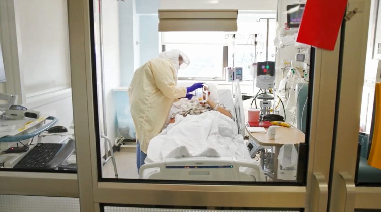 In this screen capture from a Maine Medical Center video posted on their Facebook page on September 3, an ICU nurse cares for a COVID-19 patient at Maine Medical Center in Portland. (Screen capture from Maine Medical Center video)