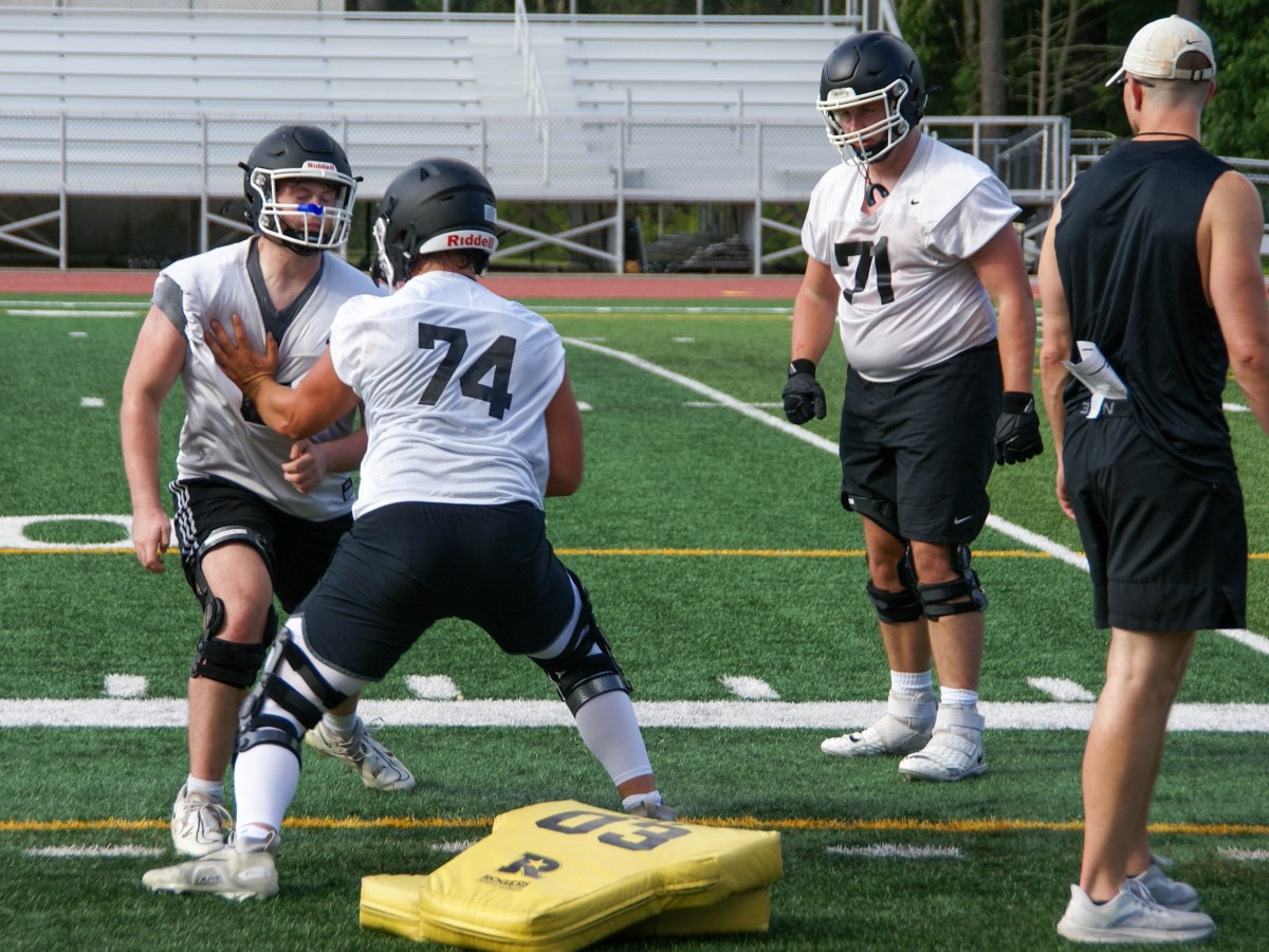 Offensive line coach Mike Deitrick watches junior Ethan Ecsedy participate in a blocking drill on Thursday, Aug. 22, 2024.